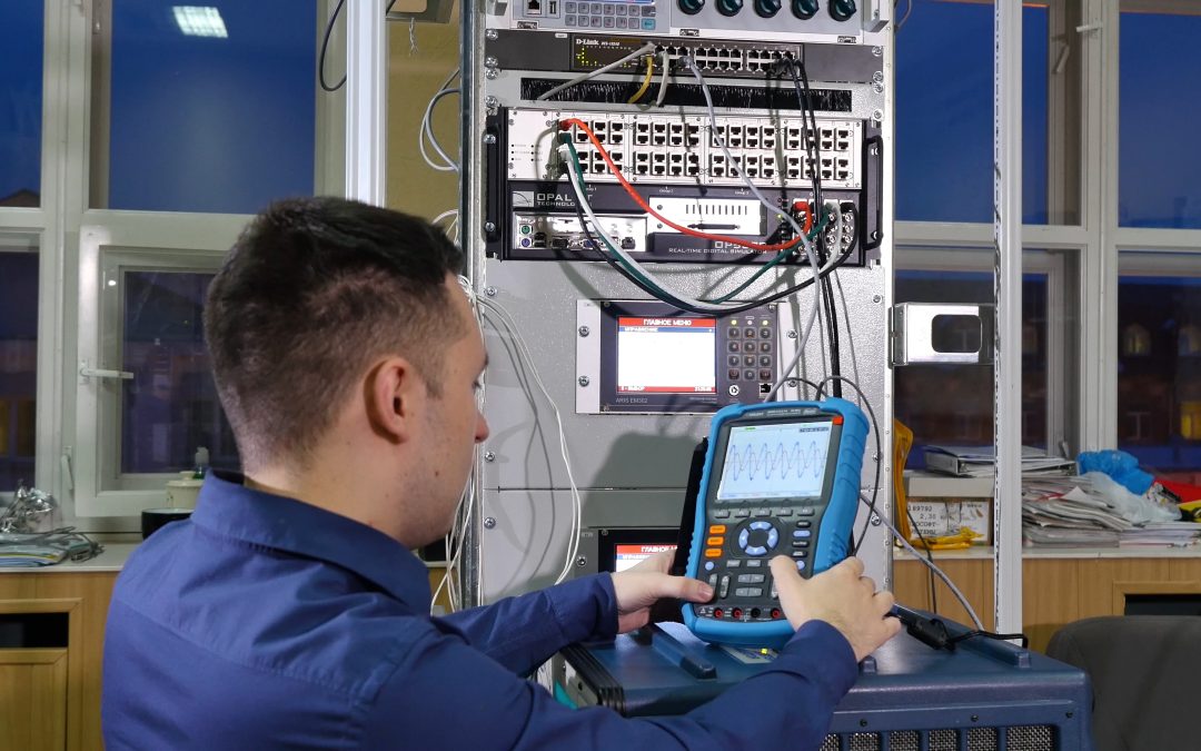 A technician uses a diagnostic device in front of a server rack with cables and equipment, ensuring precise scale repair for industrial weighing systems and pallet scales.